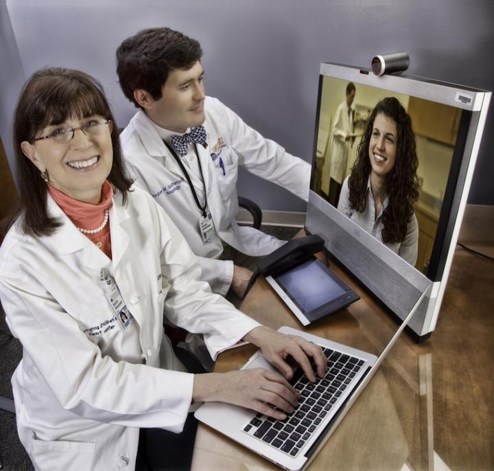 UVA Health's Karen Rheuban, MD, and Andrew Southerland, MD, demonstrate telehealth in an image taken before the pandemic. Source: Jackson Smith/UVA Health