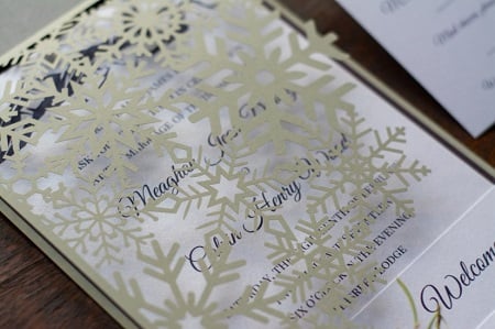 Figure 2: This winter-themed invitation suite from Platypus Papers features a laser-cut snowflake wrap complementing laser-cut and engraved place cards.  Source: Season Hurd