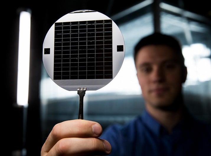A researcher holds up a disc of microchip that have flexible glass membranes. Source: Brigham Young University  