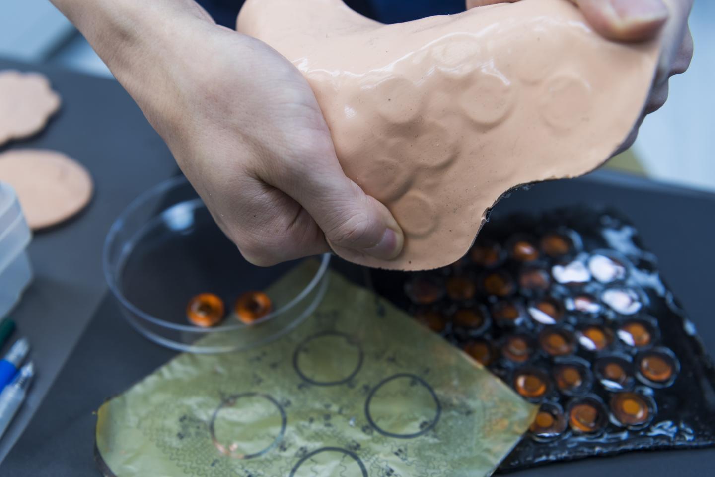 Functional components were integrated into a thin elastomeric layer with a thickness of only 3 mm. A total of 32 haptic actuators are controlled in four groups, by eight independently controllable communication ports in the device. Source: City University of Hong Kong