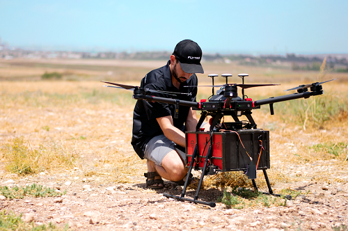 A worker readies a drone for a delivery run. Source: Flytrex