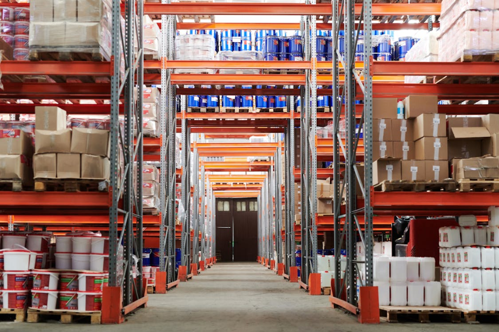High-density steel racking and shelving units line a central aisle in a storage facility. Source: Tiger Lily/Pexels