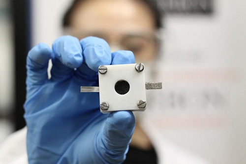 A researcher holds a rechargeable zinc-air battery. Source: University of Sydney  