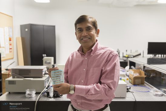 Jayan Thomas, associate professor and nanotechnology scientist at UCF’s NanoScience Technology Center, shows off the technology used to create clothing that could provide power to gadgets. Source: UCF 