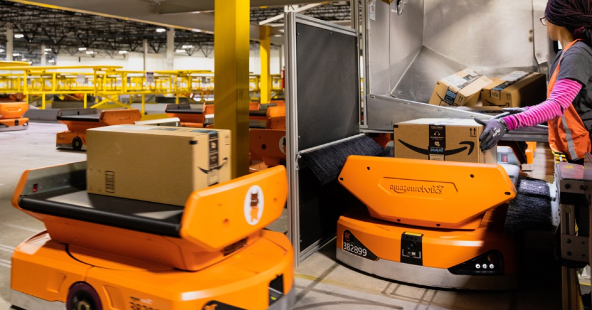 A worker loads packages on a Pegasus robot. Source: Amazon/DayOne