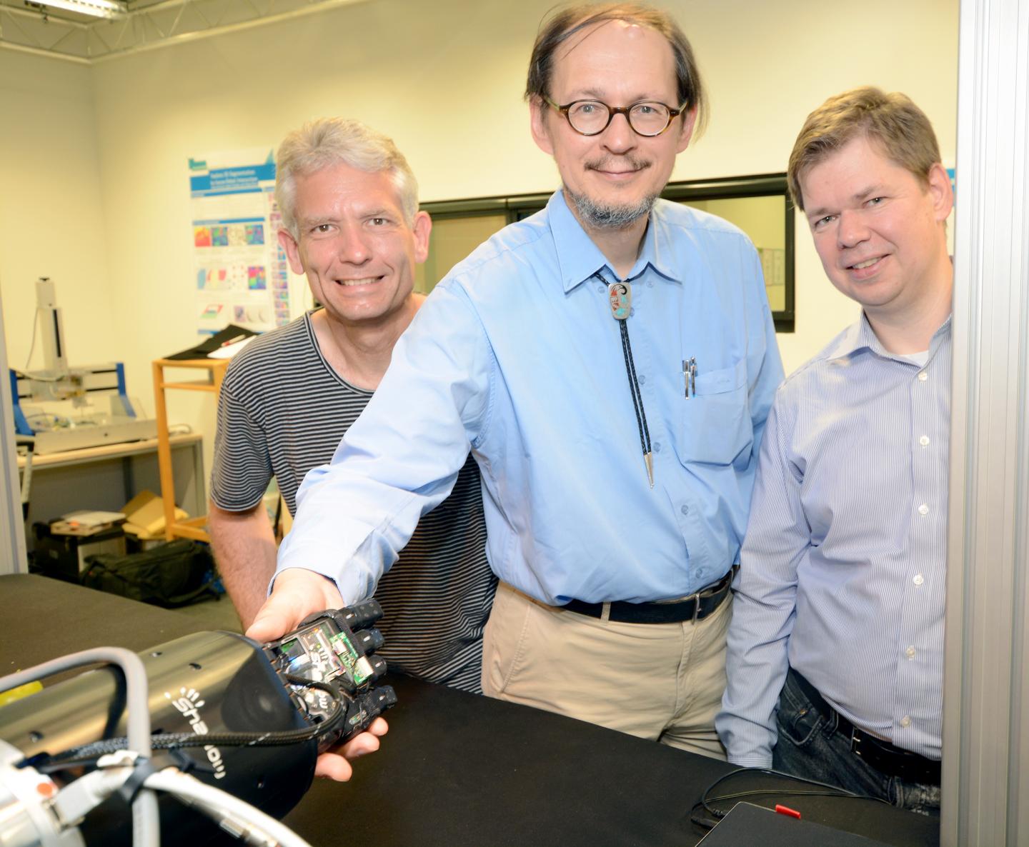 Some of the FAMULA team, shaking hands with their robot. (Credit: Bielefeld University)